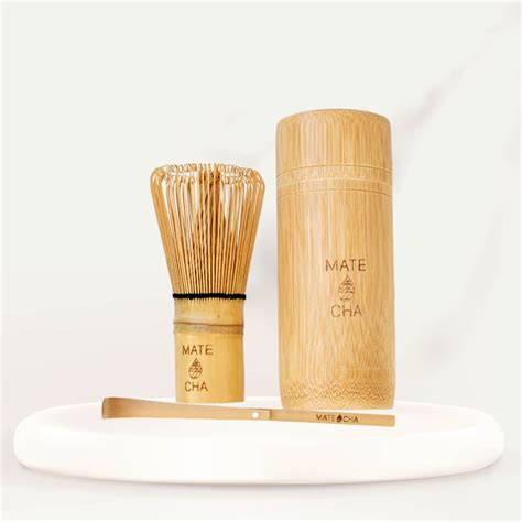 A Bamboo Brush And Comb Sitting On A White Plate Next To A Wooden