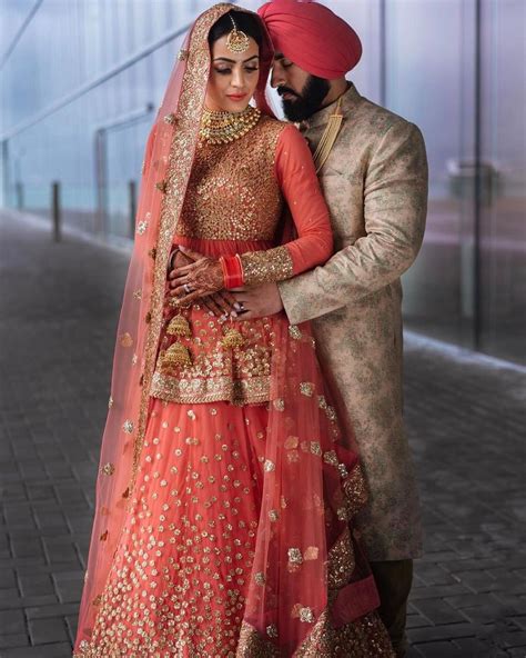 punjabi bride and groom in a coordinated pink and gold wedding lehenga and sherwani dupatta