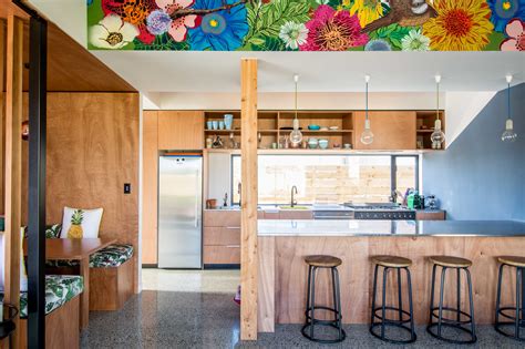 An Open Kitchen With Colorful Flowers Painted On The Ceiling And Bar