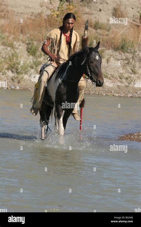 A Native American Sioux Indian Boy On Horseback Riding Across A Stock