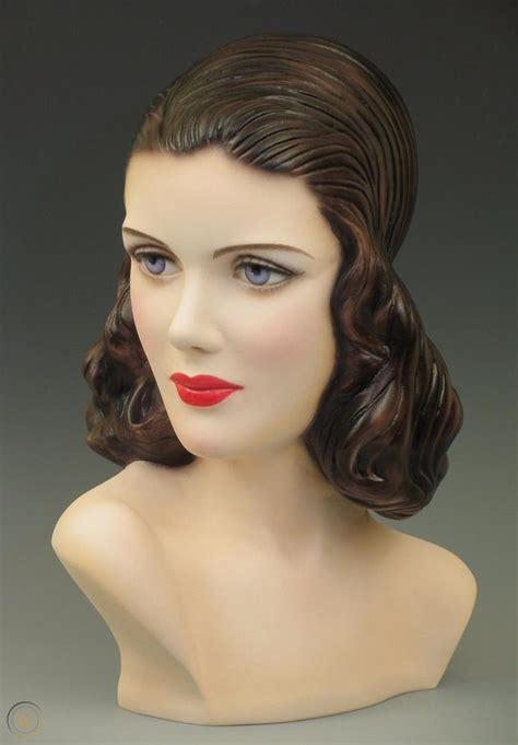 A Female Mannequin Head With Dark Hair And Red Lipstick