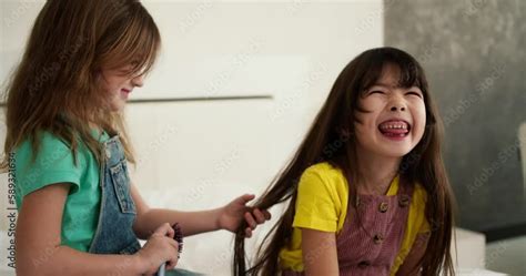 Lovely Little Cute Girl Combing The Hair Of Her Older Sister And While