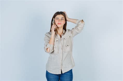 Jeune Femme Parlant Au Téléphone Portable En Pull Beige Jeans Et Lair