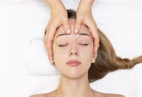 Young Woman Enjoying Massage In Spa Salon Face Massage Closeup Of