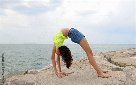 Young Girl Performing Gymnastic Exercises Arching Her Back And Creating A Kind Of Bridge With