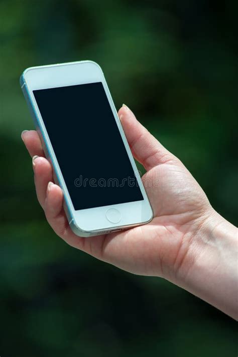 Hand Holding Phone Against Green Bokeh Background Stock Photos Free