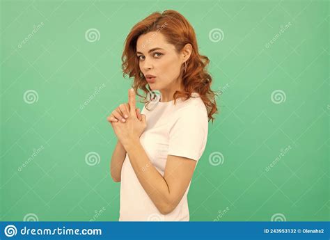 Serious Confident Redhead Girl With Curly Hair With Gun Gesture On Blue