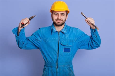 Picture Of Strong Pleasant Young Builder Looking Directly At Camera