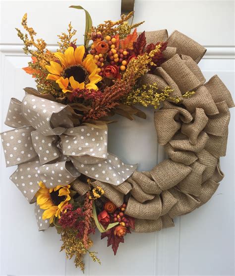A Wreath With Sunflowers And Other Flowers Hanging On The Front Door