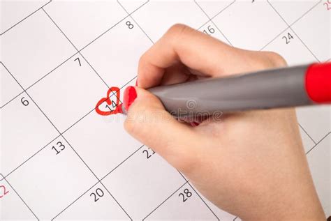 Women Hand With Pencil Drawing Heart Shape In Calendar For Valentines