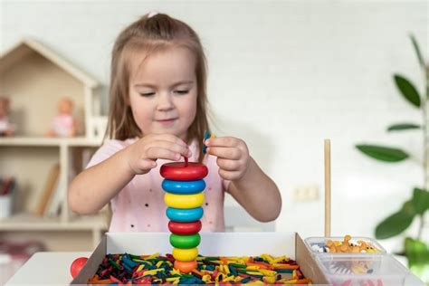 Bambina Che Gioca Con Piramide Di Legno E Pasta Colorata Gioco