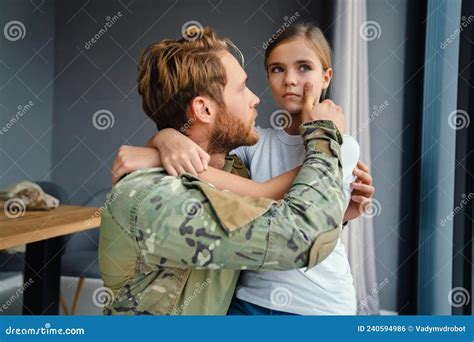 Masculine Military Man Hugging Her Crying Daughter While Kneeling Stock
