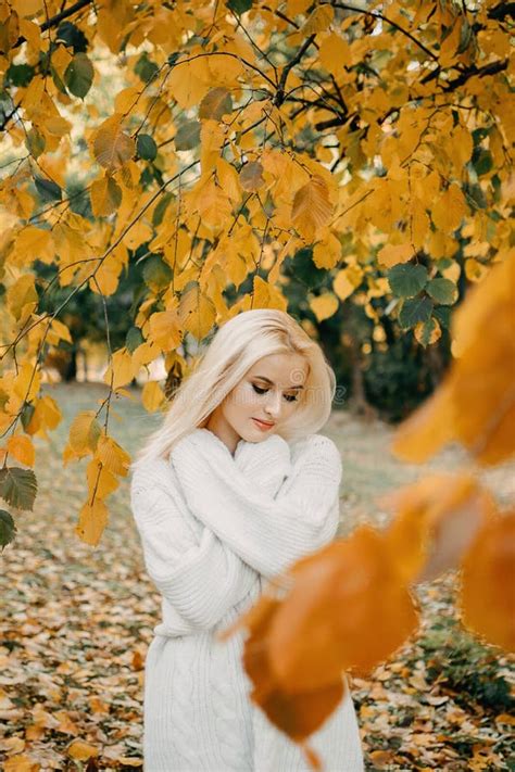 Beautiful Blonde Woman With Autumn Leaves On Fall Nature Background