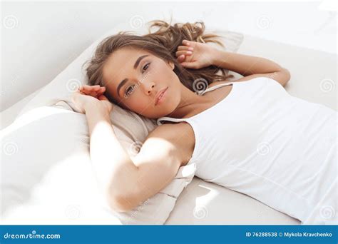 Young Beautiful Cheerful Girl Lying On Bed Early In Morning Stock