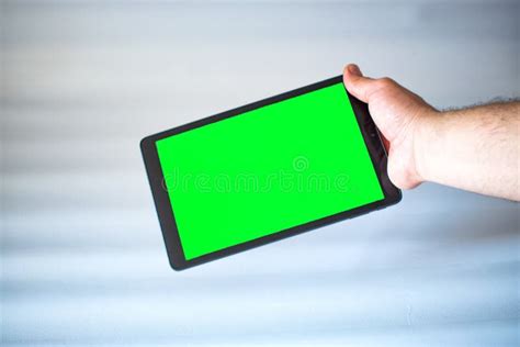 Tablet With Green Screen Fastened With One Hand On White Background