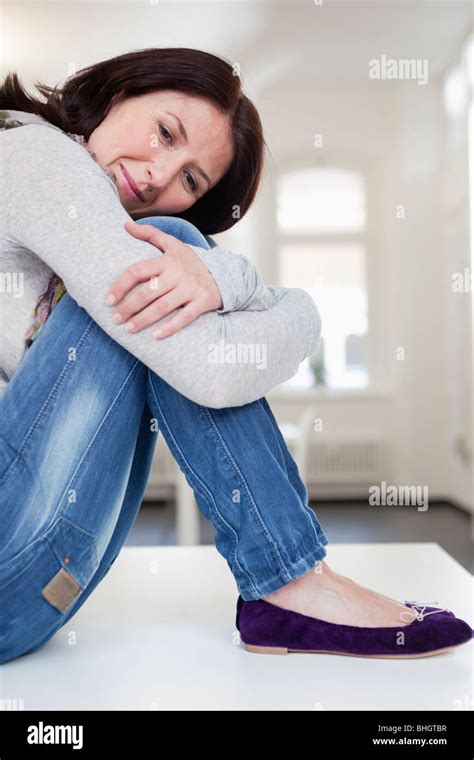 Woman Resting Head On Her Knees Stock Photo Alamy