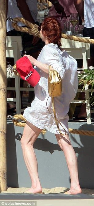 Lindsay Lohan Gives A Cheeky Flash Of Her Derriere In Skimpy Swimwear