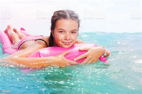 สาววัยรุ่นน่ารักนอนบน Matrass ในทะเล ภาพสต็อก ดาวน์โหลดรูปภาพตอนนี้
