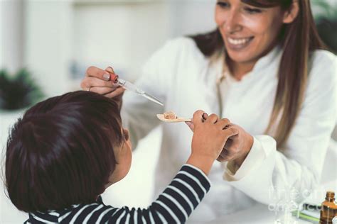 Homeopath Giving Remedy To Child Photograph By Microgen Imagesscience