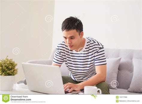 Asian Man Sitting On Couch With Laptop Stock Photo Image Of Sofa