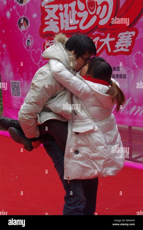 A Young Chinese Couple Performs A Kissing Stunt At A Kiss Contest To