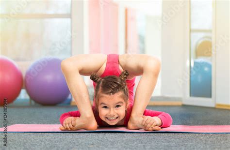 Flexible Babe Girl Gymnast Doing Acrobatic Exercise In Gym Buy This Stock Photo And Explore