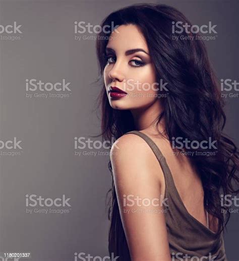 beautiful bright makeup woman with long black curly hair style in green elegant dress burgundy