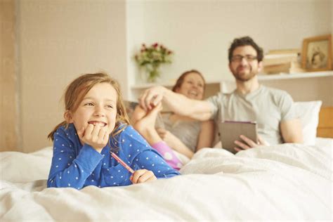 Mid Adult Couple Tickling Daughters Bare Feet Whilst Having Lie In