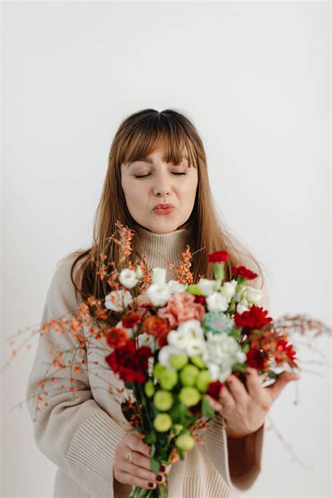 foto da mão de uma mulher segurando flores brancas na frente de um