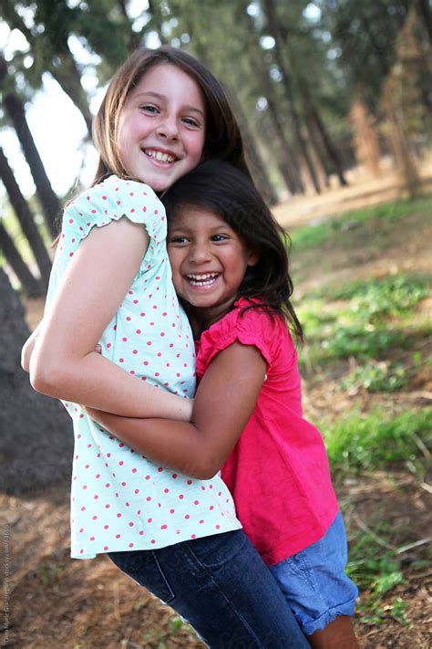 Two Girls Hugging And Laughing Outdoors By Stocksy Contributor Dina Marie Giangregorio Stocksy