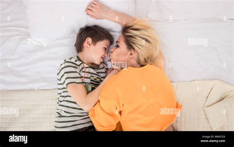 Mutter mit Sohn auf dem Bett Mutter küssen ihrem Sohn Mutter und Sohn