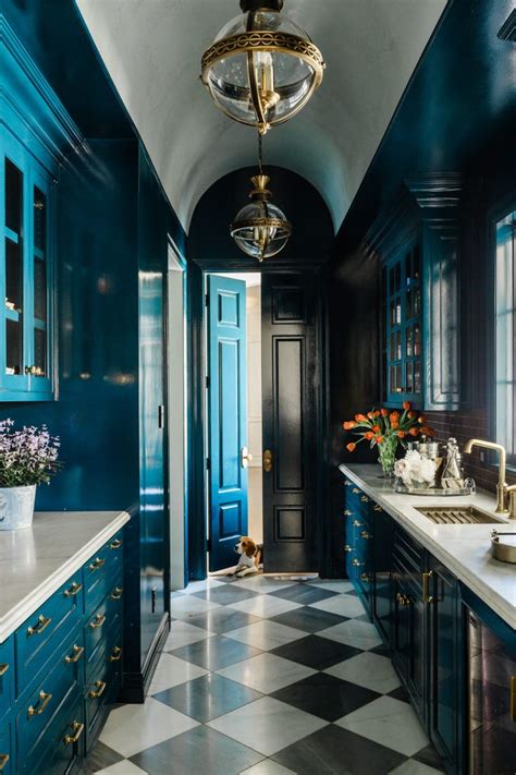 Using white cabinets in the kitchen is a smart design move, as they'll give the space a light and airy feeling. Teal kitchen cabinets + white countertops + gold pendant lights + gold hardware + black and ...