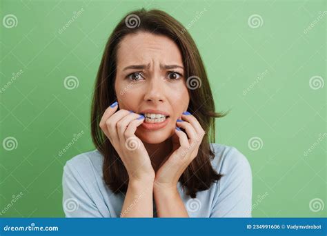 Young European Scared Woman Looking At Camera While Biting Her Fingers