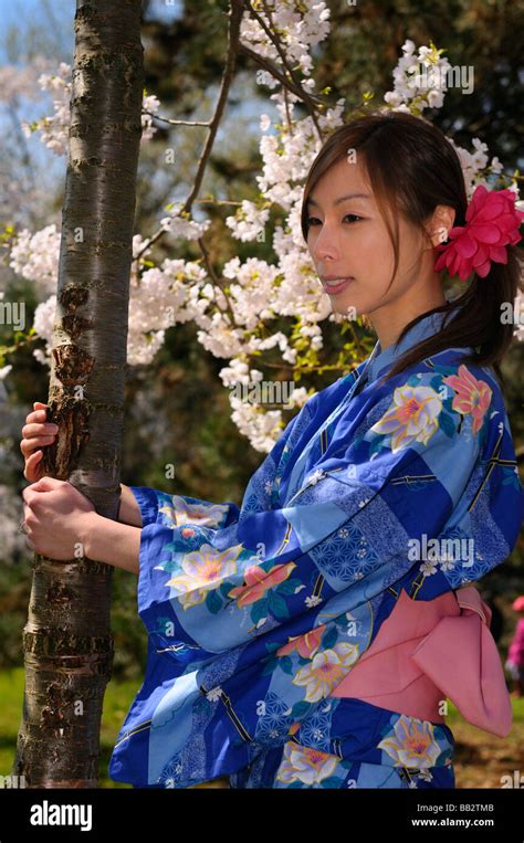 Junge Japanische Frau In Einem Kimono Holding Den Stamm Eines Blühenden