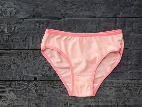 premium photo women s pink cotton panties on black wooden surface