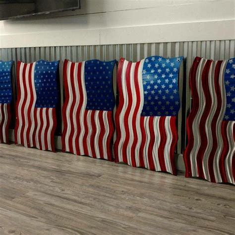 Four American Flags Are Lined Up On The Floor In Front Of A Flat Screen Tv