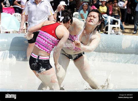 Two Chinese Women Wrestle In A Mud Pool During An Interntional Womens Mud Wrestling Contest