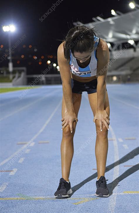 Exhausted Female Track And Field Athlete After Race On Track Stock