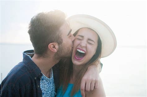 A Young Couple Laughing And Kissing While On Vacation By Stocksy