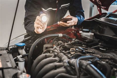 Asian Man Mechanic Inspection Shine A Torch On Car Engine Checking Bug