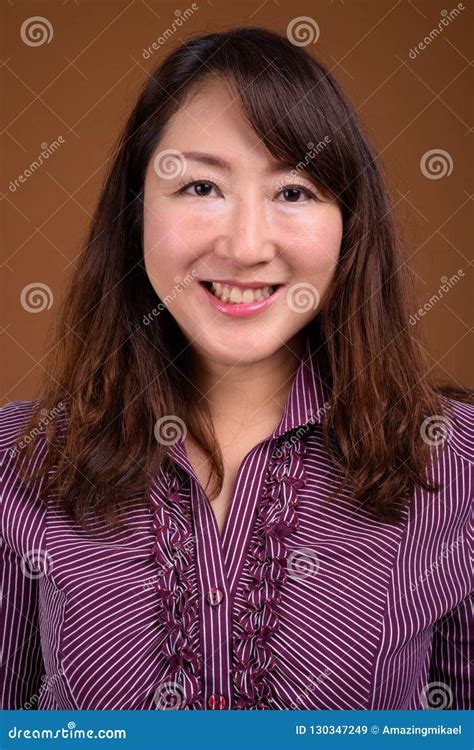 dojrzały piękny azjatycki bizneswoman przeciw brązu tłu obraz stock obraz złożonej z purpury