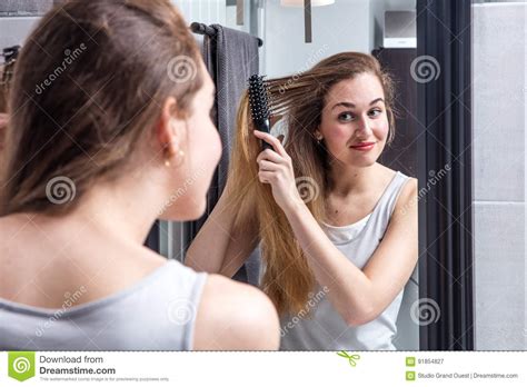 Happy Young Woman Brushing Long Hair In Front Of Mirror Stock Image Image Of Female Preparing