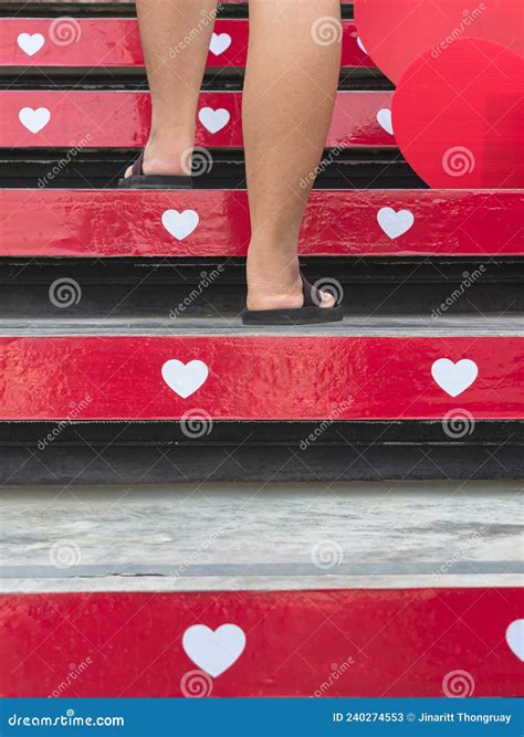 Feet Of Young Woman Walk Up The Stairs Decorated With Beautiful Red And White Hearts On Occasion