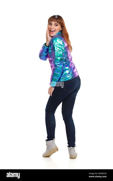 Excited Young Woman In Vibrant And Shiny Down Jacket Is Standing
