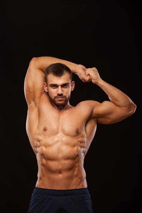 Strong Athletic Man Fitness Model Is Showing His Torso With Six Pack Abs And Holding His Hands