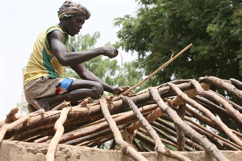 A Man Rebuilding His Roof In A Village Near The Northwestern Central