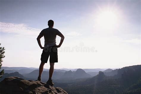 Self Confident Hiker In Akkimbo Pose On The Peak Of Rock Stock Image