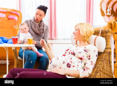 Happy Mothers Talking About Pregnancy At Midwife Practice Stock Photo