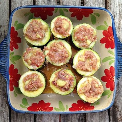 A Blue And White Plate Topped With Cucumbers Covered In Toppings On Top