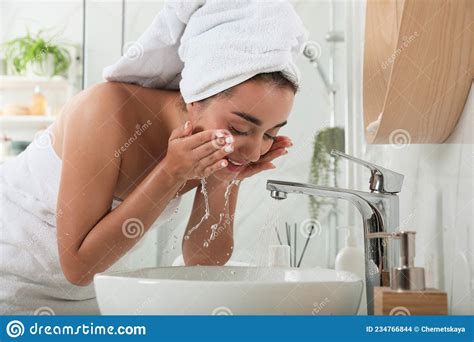 Beautiful Young Woman Washing Her Face With Water In Bathroom Stock